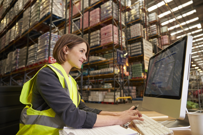 Woman working on computer in the warehouse