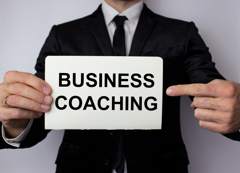 man pointing to sign business coaching